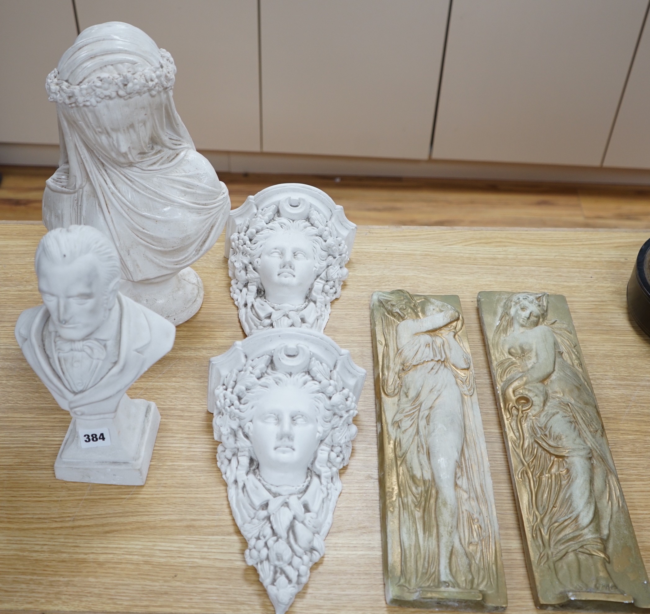 A pair of plaster wall sconces and wall panels, and two busts, tallest 38cms high